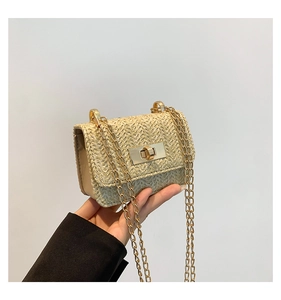 Detail of mini straw crossbody bag with golden twist lock and chain strap for summer