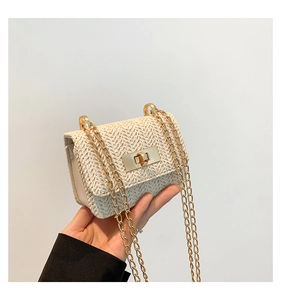 Detail of cream woven flap bag featuring V-shaped texture and gold metal chain strap