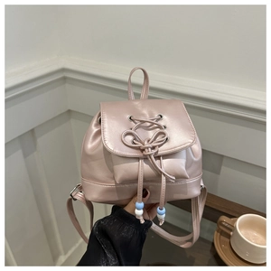 Détail d'un mini sac à dos rose perlé avec cordon à nœud et perles bleues et blanches