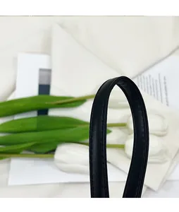 Detailed close-up of a black leather crescent bag strap with premium stitched edging