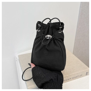 Close-up of black drawstring bucket bag featuring silver eyelets and high-quality nylon texture