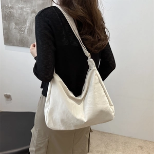 Minimalist white large hobo tote bag with soft pleated texture on female model