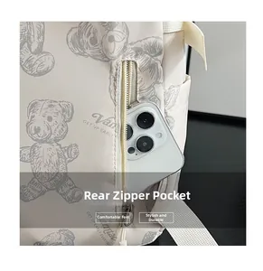 Detail of hidden rear zipper pocket on beige teddy bear backpack with smartphone