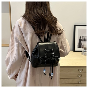 Détail d'un mini sac à dos en cuir PU noir avec lacet et cordon de serrage à perles
