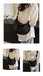 Close-up of black nylon hobo bag with adjustable wide strap and silver metal zipper