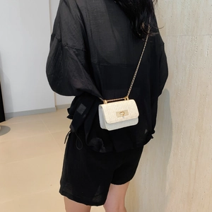 Minimalist woven crossbody bag with gold chain and metal lock for summer casual style