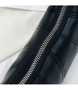 Detail shot of silver metal zipper and black quilted leather texture on shoulder bag