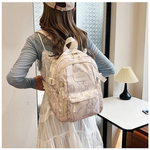 Detail showing beige backpack with cute brown bear prints and smooth zipper pockets