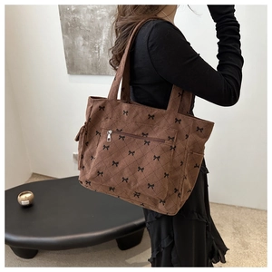 Brown corduroy tote bag with black bow prints and a convenient front zipper pocket