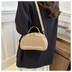 Detailed side view of a beige quilted shoulder bag with FASHION BAGS gold lettering