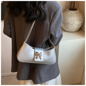 Détail du sac sous le bras en cuir PU argenté avec un nœud papillon métallique