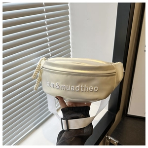 Détail du sac banane blanc perlé avec lettres brodées et fermeture éclair métallique