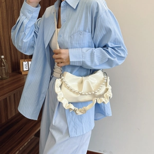 White ruched underarm bag with pearl chain and bow detail on a stylish shoulder strap