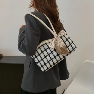 Classic black and white checkered tweed tote bag with stylish bow scarf on a model
