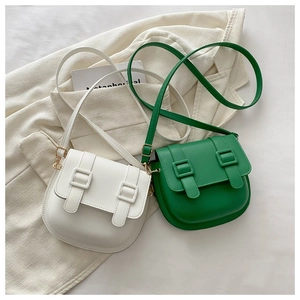 Detail shot of vintage saddle bags in white and bright green with golden hardware