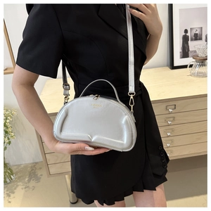 Detailed view of silver crescent moon shoulder bag with embossed Fashion Bags text