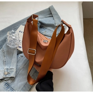 Terracotta nylon crescent bag detail showing wide strap and metallic silver hardware
