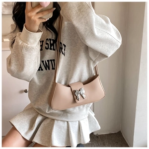 Selfie miroir montrant le sac kaki avec un détail de nœud papillon argenté poli