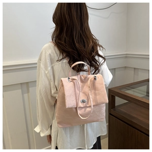 Vue arrière d'un mannequin portant un sac à dos en nylon rose à texture froissée
