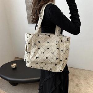 Chic off-white corduroy tote bag with black bow print and diamond lattice pattern