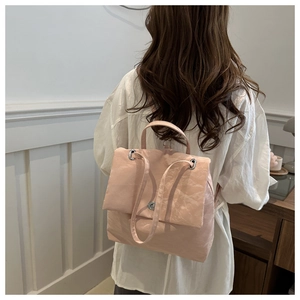 Détail du sac à dos rose clair plissé avec fermoir rotatif porté par un mannequin