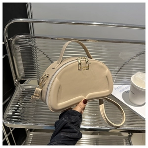 Detailed macro view of beige semi-circular handbag featuring 3D embossed logo text