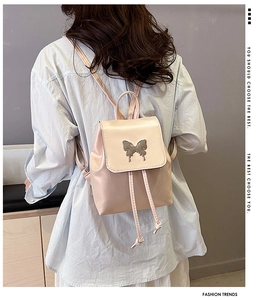 Close-up of pink PU leather mini backpack with silver butterfly charm and drawstring
