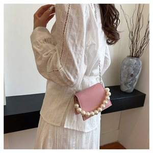 Pink mini crossbody bag featuring cream pearl accents and a silver chain strap detail