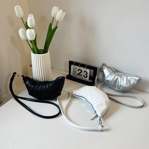Minimalist croissant shoulder bag in black, white, and silver with chain detail
