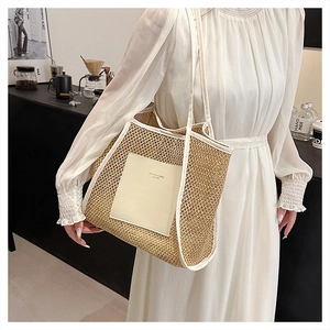 Close-up of woven straw tote bag with white leather trim and square patch detail