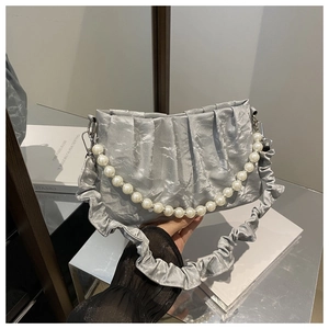 Detail of silver pleated handbag with large pearl chain and ruffled shoulder strap