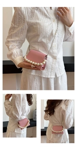 Detail of pink mini shoulder bag with large pearl handle and silver chain strap