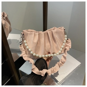 Detailed view of pink pleated satin handbag with elegant pearl handle and ruffle strap