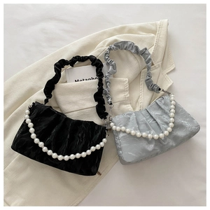 Detail of the pleated cloud bag featuring pearl handle and textured finish for women
