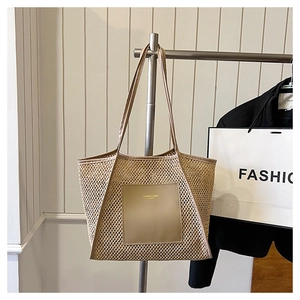 Detail of khaki woven mesh tote bag with leather handles and fashion lettering