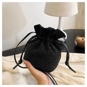 Close-up of black suede bucket bag with luxury rhinestone crystals and drawstring detail