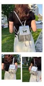 Detail of silver metallic backpack featuring a decorative butterfly buckle and drawstring