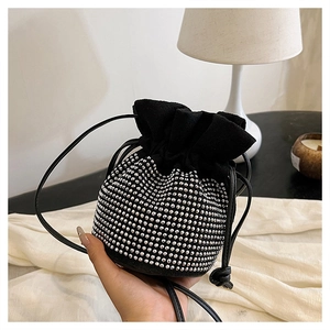 Detail of black faux suede bucket bag with sparkling silver rhinestone drawstring design