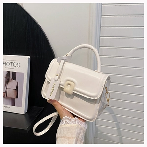 Detail of white faux leather crossbody bag with curved handle and FASHION tag