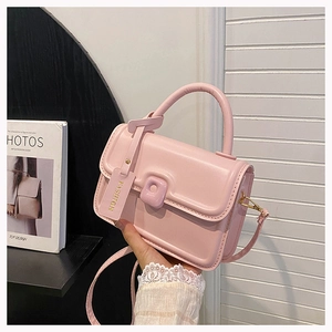 Pink leather square handbag detail with gold hardware and fashion pendant