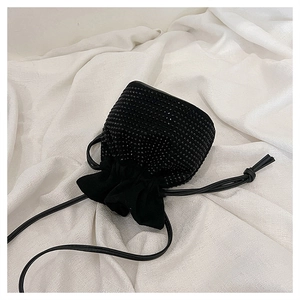 Close-up of black drawstring bucket bag featuring high-density sparkling rhinestone embellishments