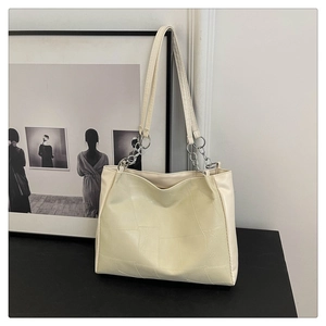 Detail of cream PU leather tote bag with geometric stitching and silver chain strap