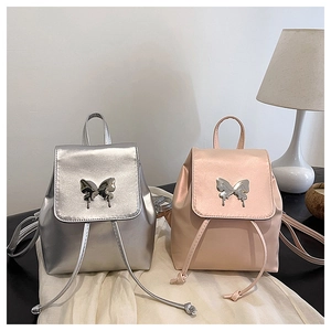 Detail view of silver and pink mini backpacks with metallic butterfly buckle and drawstring