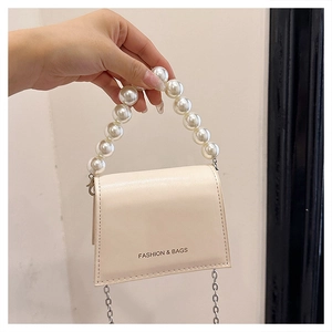 Detail of cream PU leather crossbody bag with faux pearl handle and metal chain strap