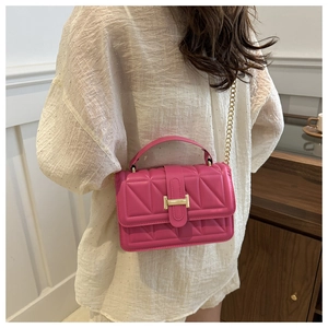 Detailed view of rose red quilted crossbody bag with gold H clasp and chain strap