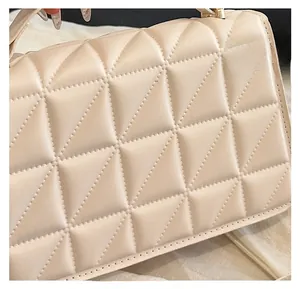 Close-up of beige quilted PU leather handbag showcasing geometric stitching detail