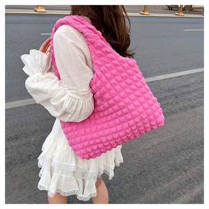 Detailed close-up of pink bubble textured shoulder bag with large capacity tote design