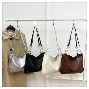 Group display of large tote bags in silver, black, beige, and brown with geometric pattern
