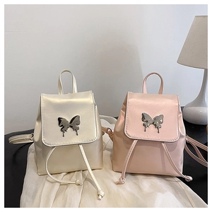 Detail of mini backpacks in champagne and pink with liquid metal butterfly hardware