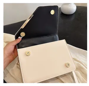 Detailed view of the gold magnetic clasps and stitching on the quilted crossbody bag